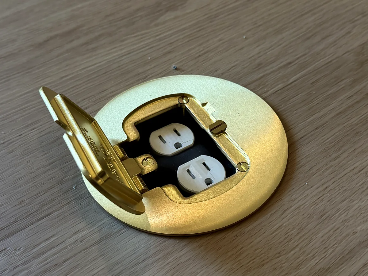 Brass floor outlet with two electrical receptacles