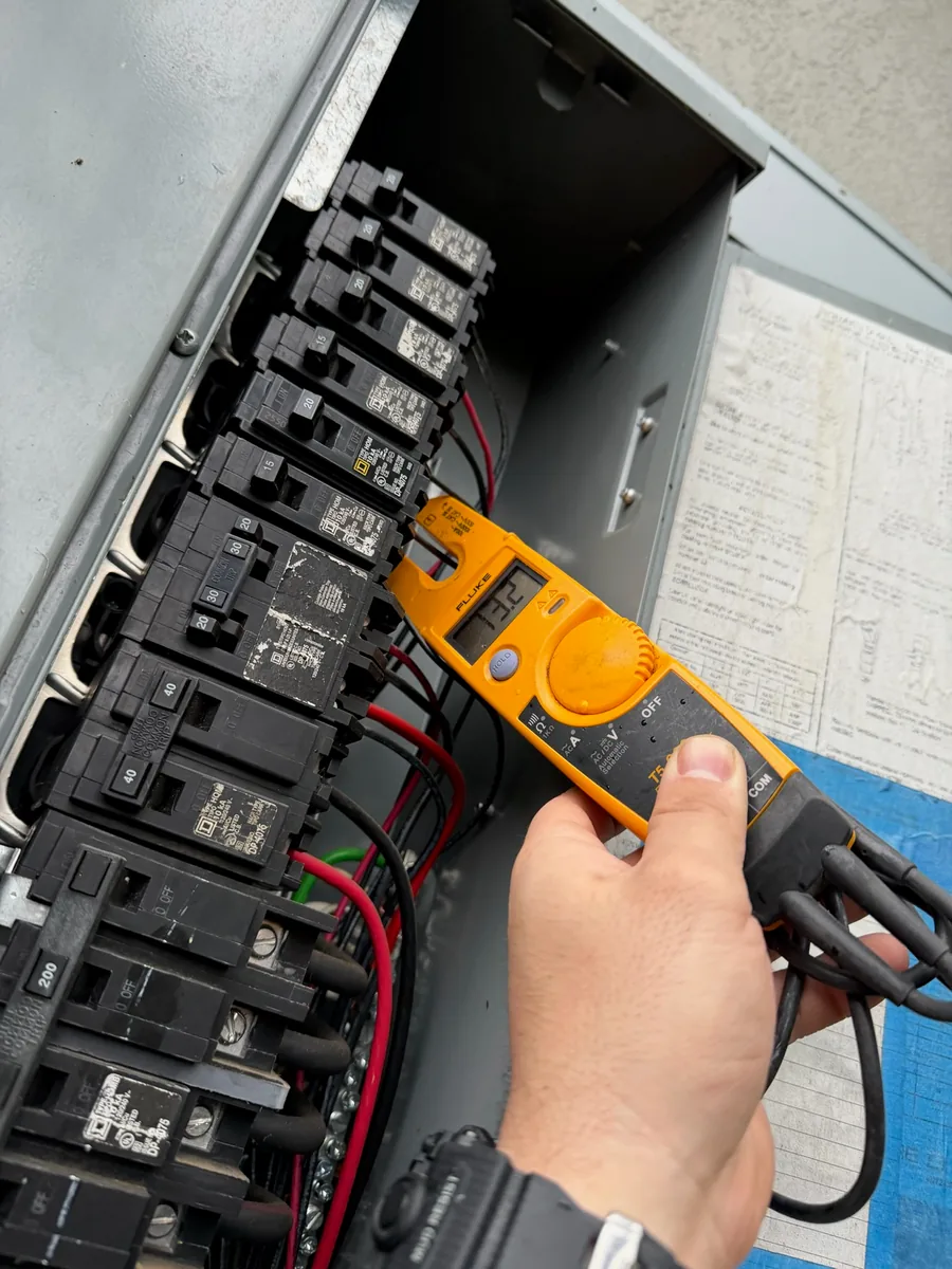 Licensed electrician performing electrical work with a hand tool